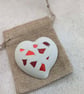 Handmade heart brooch crafted from smooth jesmonite and red aluminium pieces