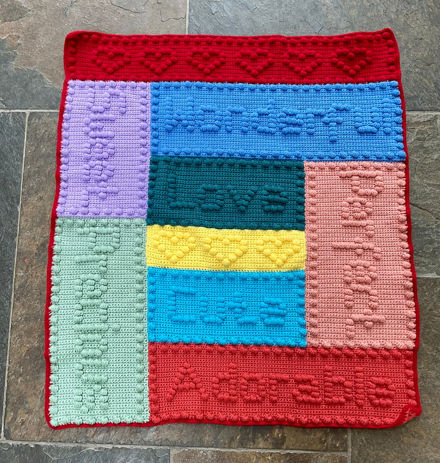 Crocheted baby blanket. Puff stitch words.
