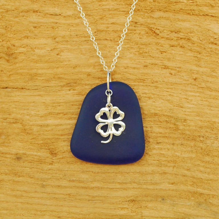 Blue beach glass pendant with lucky charm