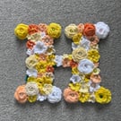 Initial H - hand made crochet flowers on plywood on back board