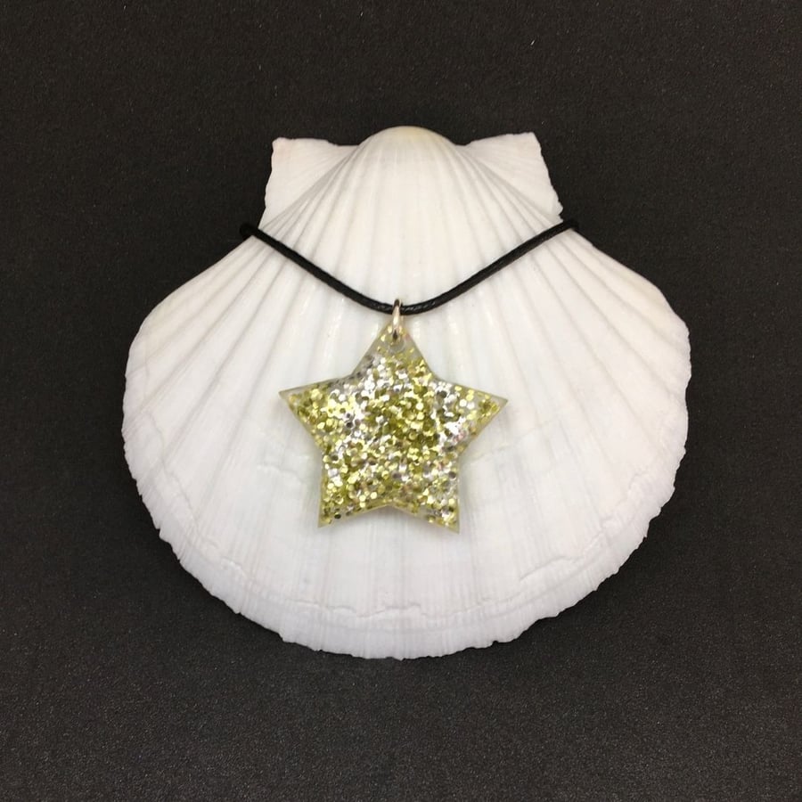 Gold and silver sparkly star pendant with black cord.