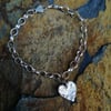 Silver bracelet with a heart charm.