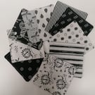 Set of 10 cotton fabric coasters in grey scale. 