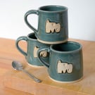 Straight sided hand thrown pottery mug with abstract shape motif glazed in blue