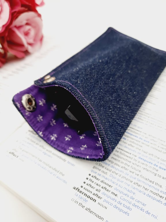 Denim glasses case with purple lining and a chrome popper.  