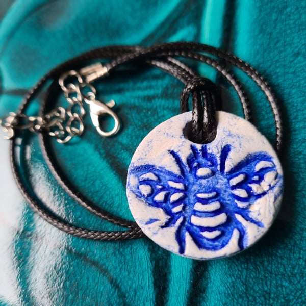 Clay round embossed bee necklace pendant blue 