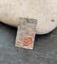 Oblong pendant in sterling silver with etched copper leaf