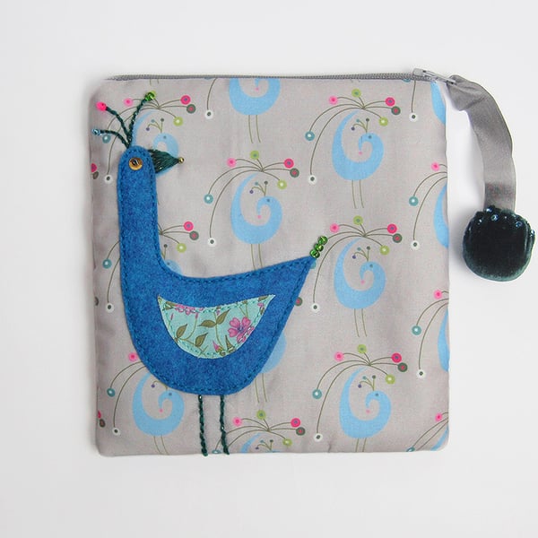 Make up bag with appliquéd bird on peacock printed cotton