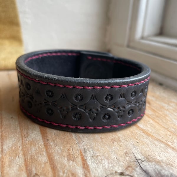 Black, Skull tooled leather bracelet cuff with wine coloured stitching.