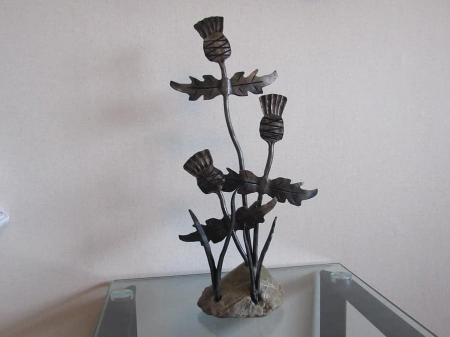 Thistle sculpture with a stone base, hand forged by a scottish blacksmith