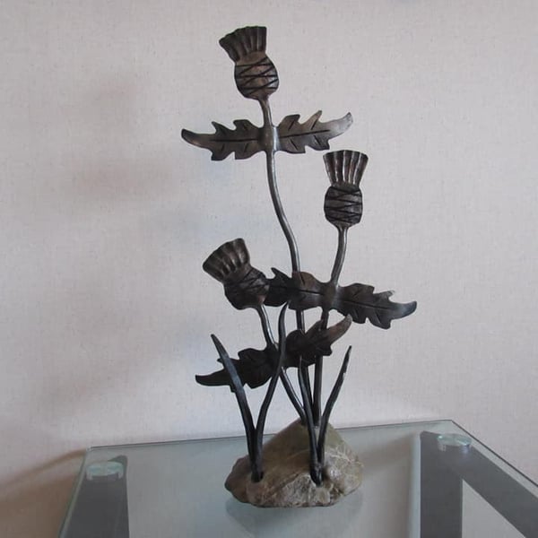 Thistle sculpture with a stone base, hand forged by a scottish blacksmith