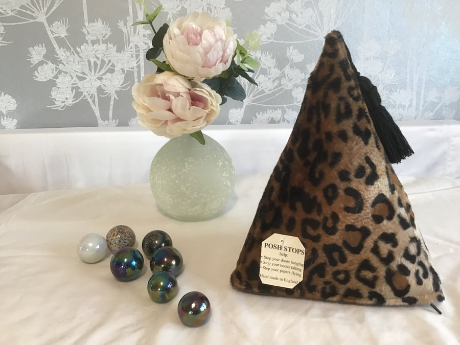 A pyramid shaped heavy fabric door stop