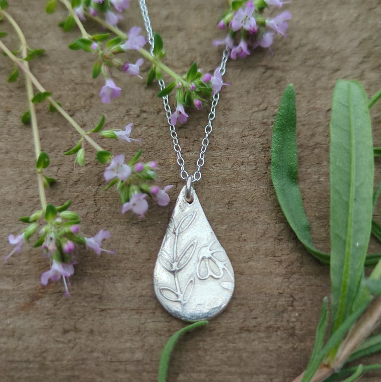 Silver tear drop pendant with flower and leaf pattern