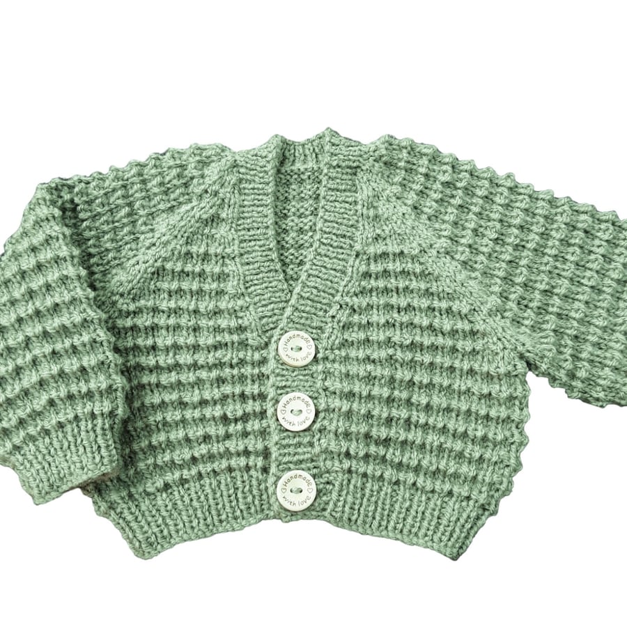Hand knitted baby cardigan in moss green textured pattern 