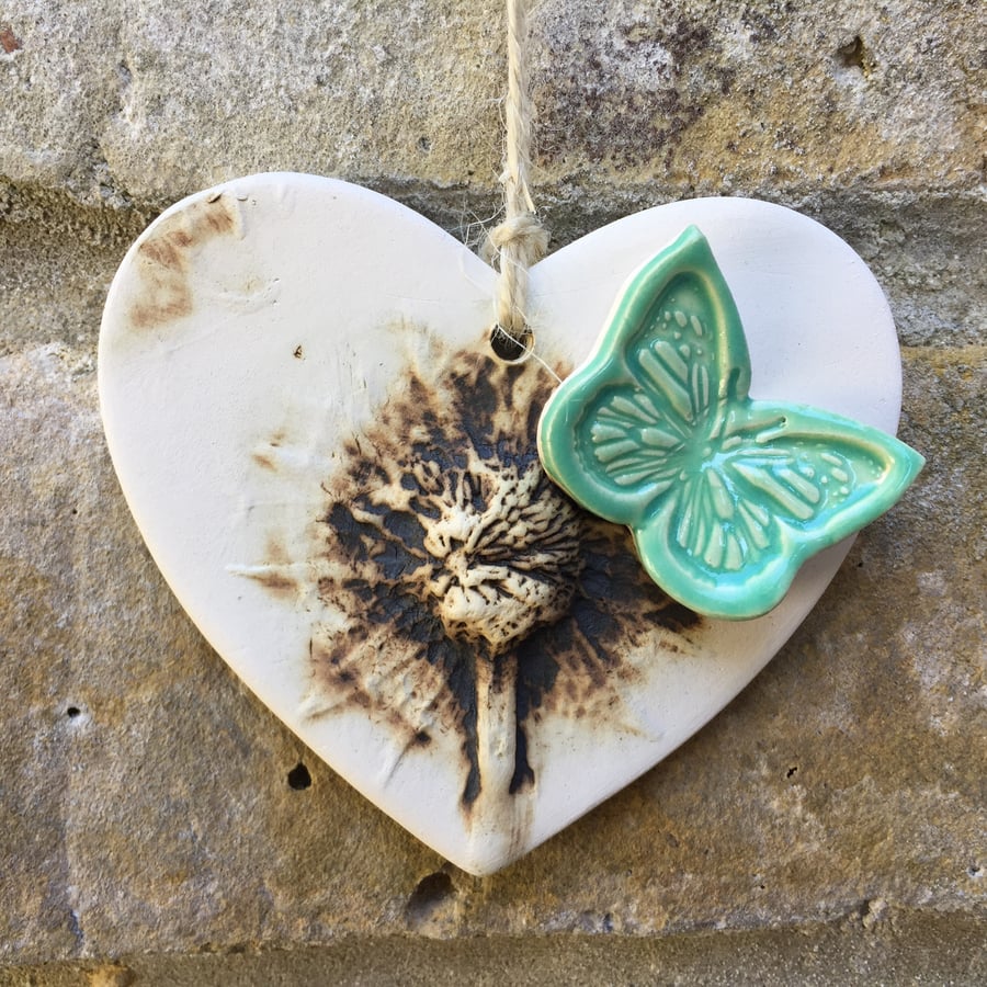 Pottery heart decoration with natural flower design and butterfly
