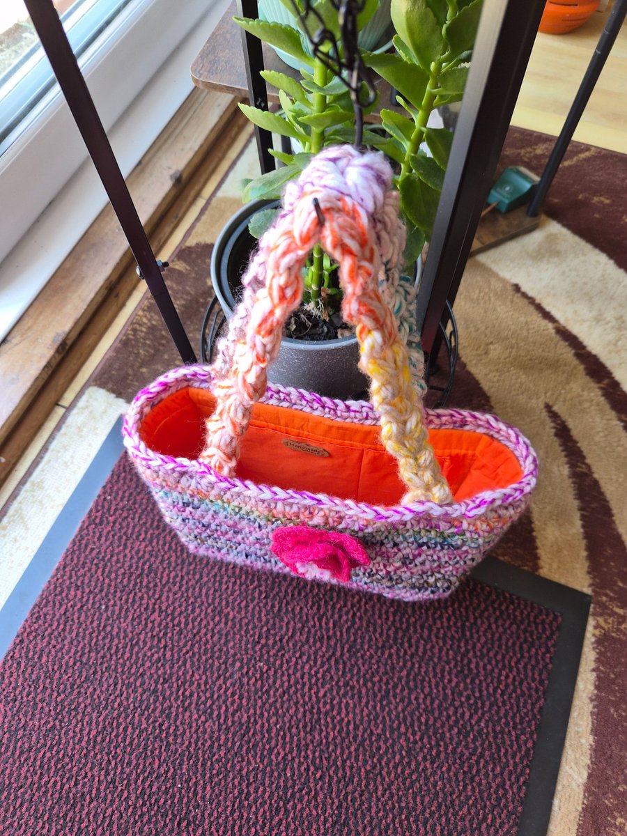 Crochet open bucket bag with crochet flower to the front and a duel inner pocket