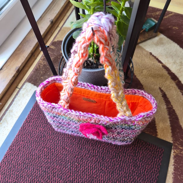 Crochet open bucket bag with crochet flower to the front and a duel inner pocket