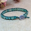Blue-green faceted agate and leather bracelet with lotus button closure 
