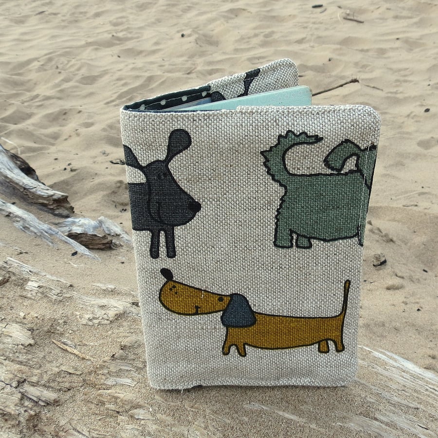 A linen passport sleeve with a whimsical dogs design.