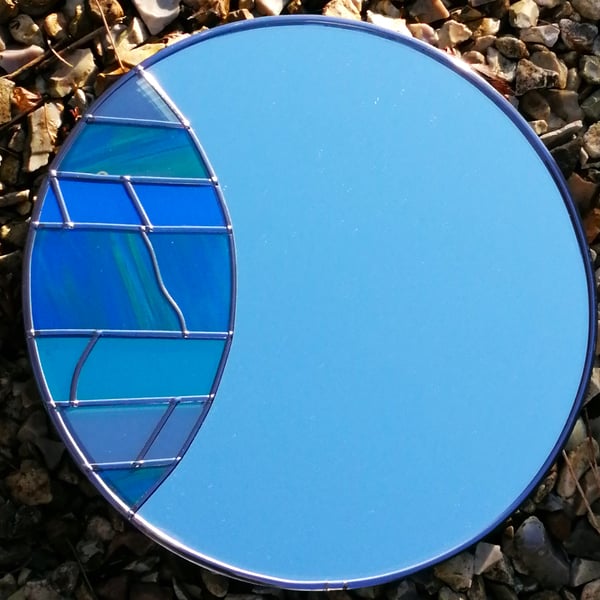 Blue Fish is a 30cm Round Stained Glass Effect Wall Mirror in shades of blues.