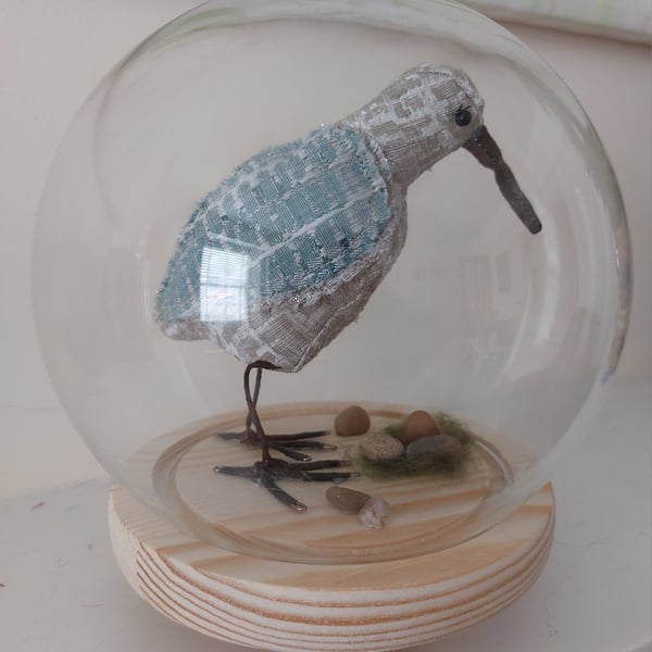 Wading bird soft sculpture in glass case.