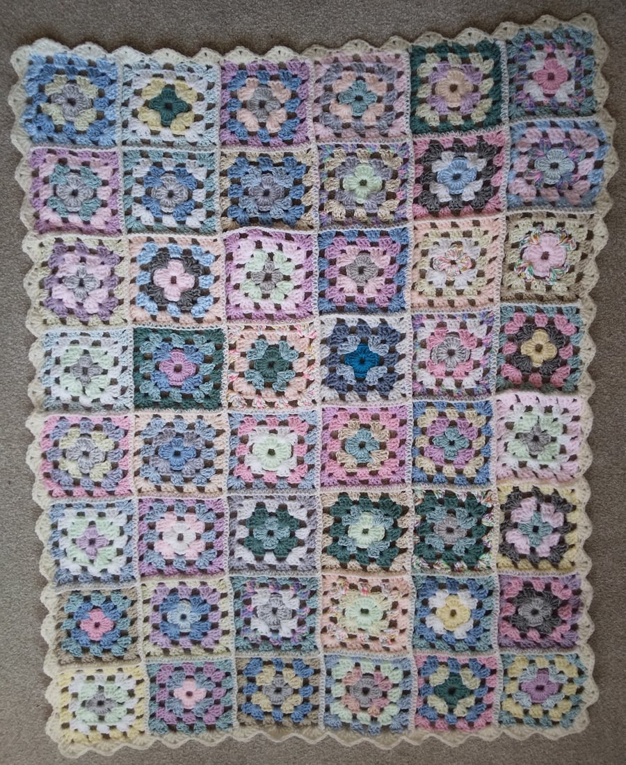 Crochet granny squares blanket in pale pastel colours.