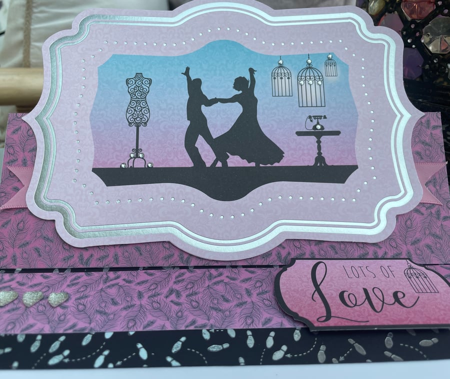 Silhouette of a dancing couple with love anniversary or birthday card