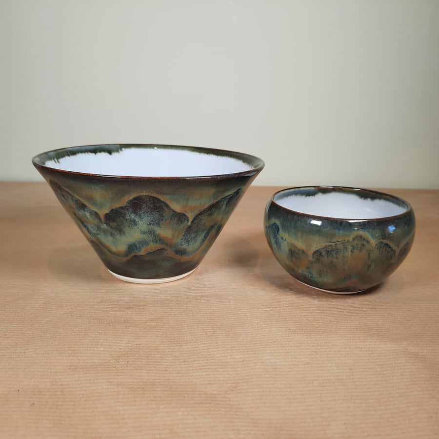A pair of hand thrown pale blue and multi stoneware bowls