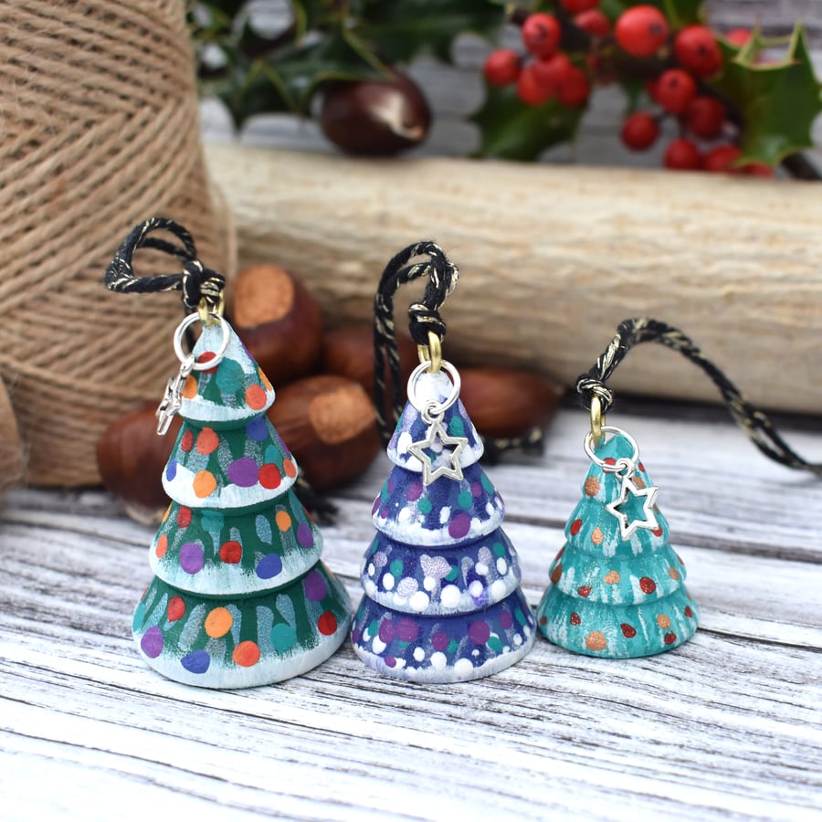Set of three small hanging multicoloured Christmas tree decorations.