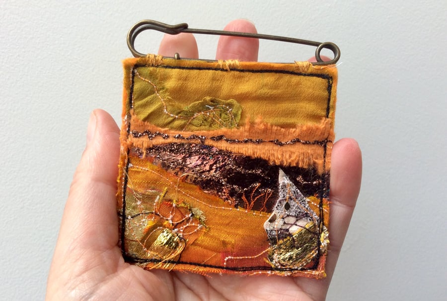 Up-cycled golden abstract landscape kilt pin brooch or badge. 