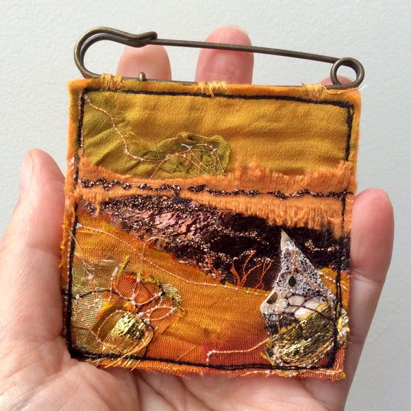Up-cycled golden abstract landscape kilt pin brooch or badge. 
