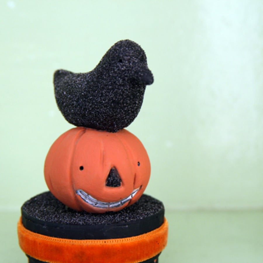 Primitive folk art Halloween crow figure on a pumpkin