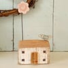 Little wooden house with clay flower and bird