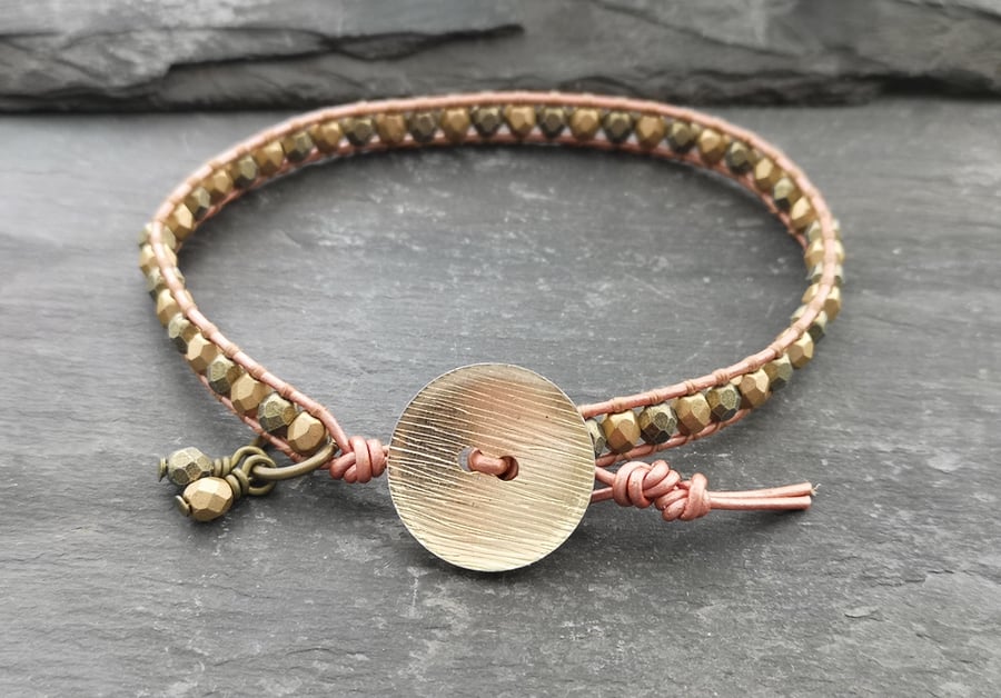 Metallic rose gold leather and glass bead bracelet with gold coloured button 