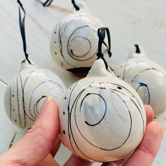 Set of four black and white swirled pebble baubles. 
