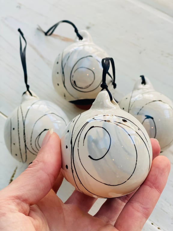 Set of four black and white swirled pebble baubles. 