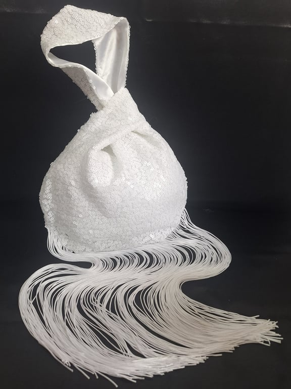 White sequin Japanese Knot bag with 29cm tassel trim and satin lining.