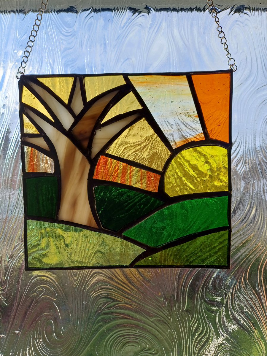 Sunset over hills and solitary tree