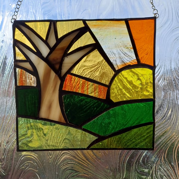 Sunset over hills and solitary tree