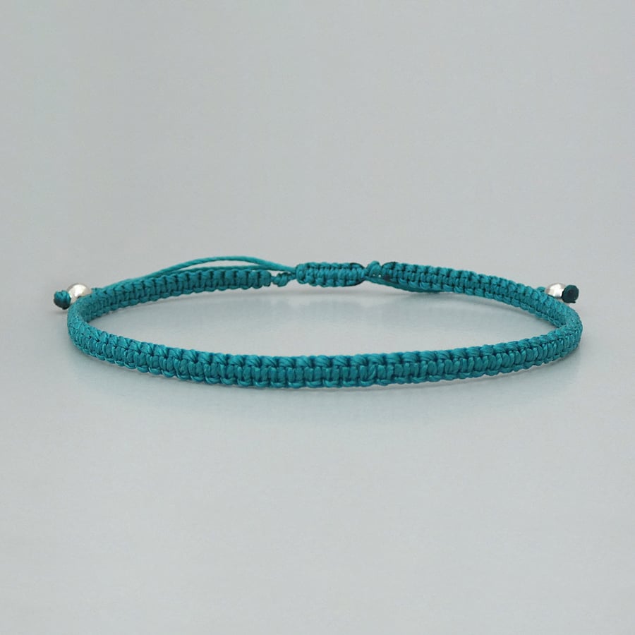 Teal macramé bracelet with silver plated bead ends. Extends from 7” to 9.5