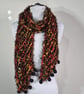 Long Thin Handknitted Scarf in Black Orange And Red With Hand Felted Baubles .