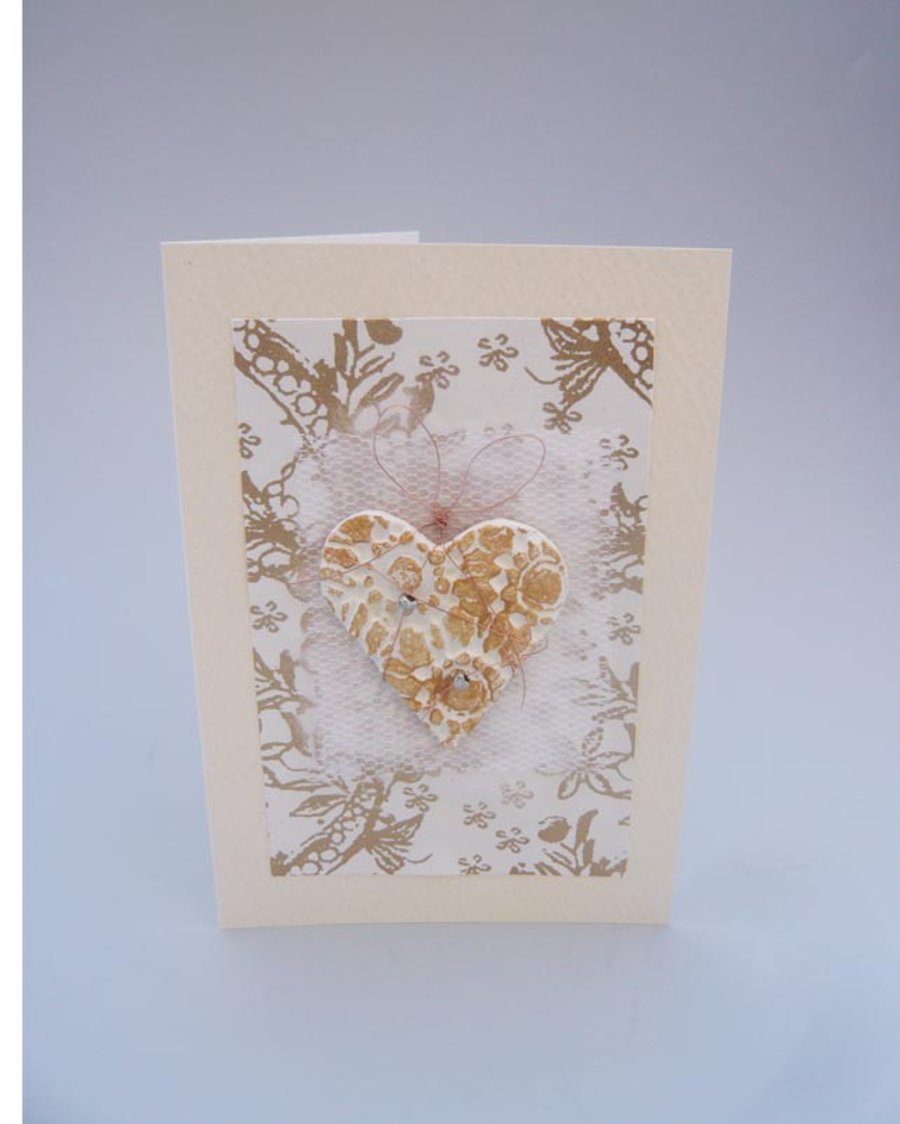 Wedding card with large white and gold textured heart.