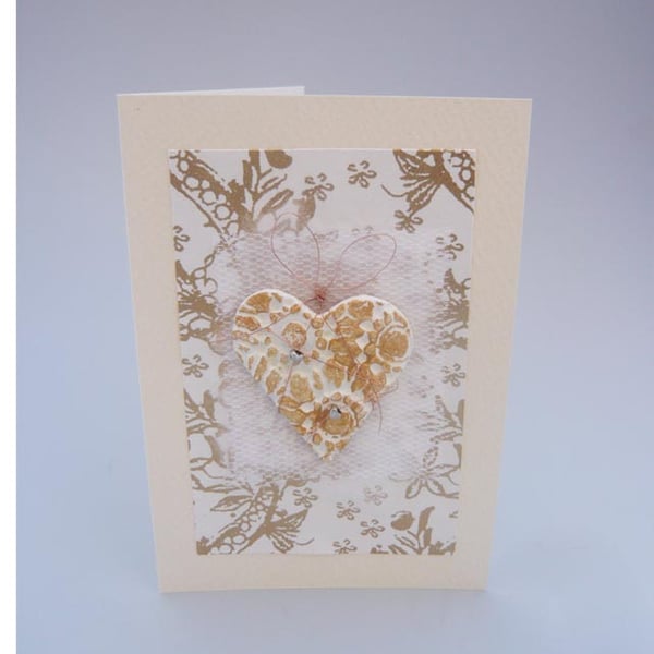 Wedding card with large white and gold textured heart.