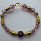 Small purple and gold coloured, Norse influenced bracelet.