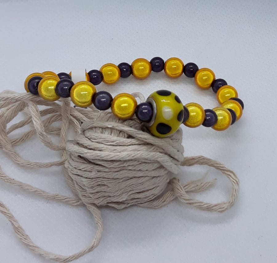 BR370 Yellow and deep plum miracle bead bracelet with glass feature bead