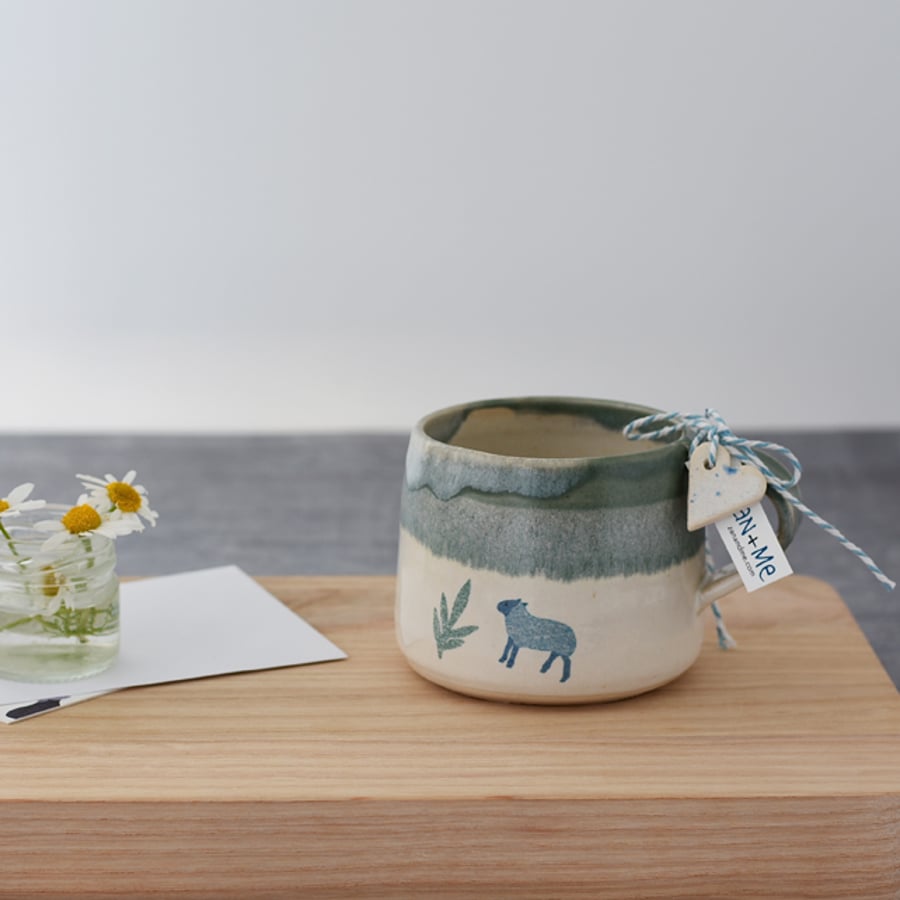 Handmade green and cream ceramic mug with sheep - illustrated pottery