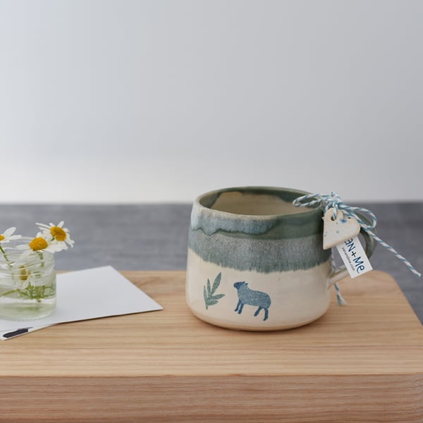 Handmade green and cream ceramic mug with sheep - illustrated pottery