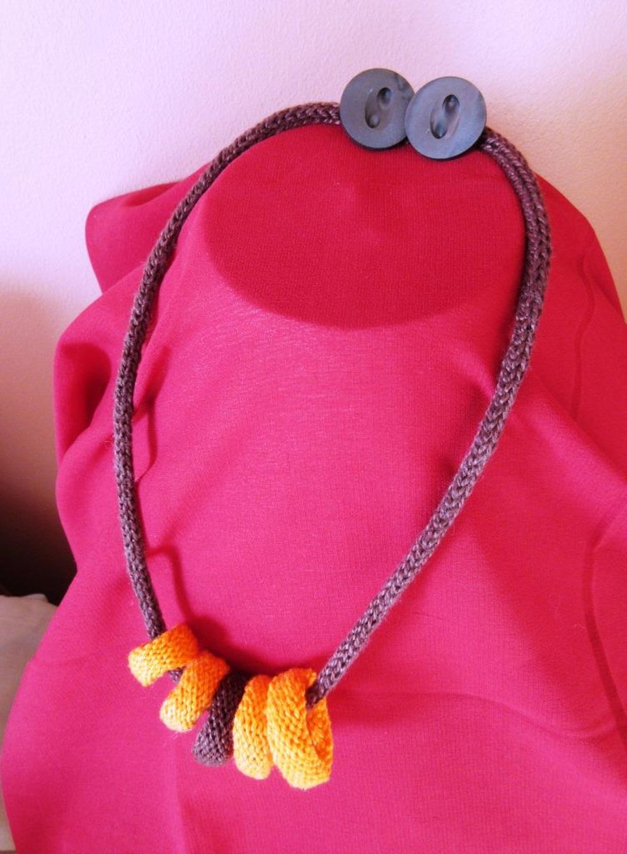 A knitted necklace of 5 knitted rings threaded on a cord of French knitting 