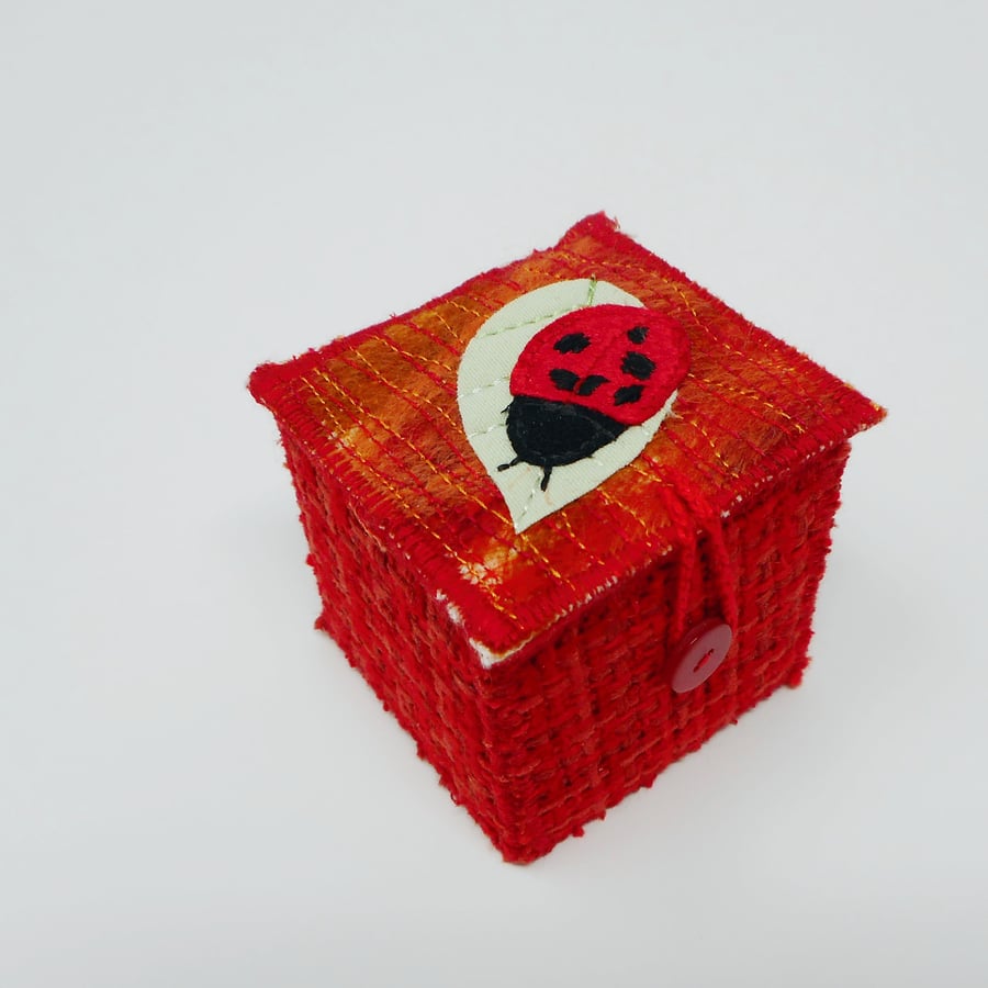 Red hand-stitched textile keepsake box with ladybird