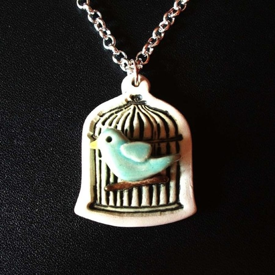 Bird in a cage ceramic pendant
